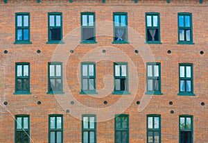 Brick wall and windows facade of urban apartments