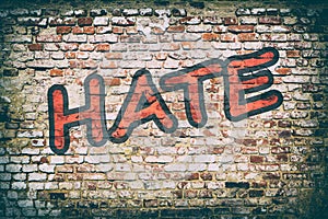 Brick wall with word hate graffiti. photo