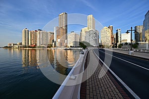 Brickell Key Bridge and City of Miami skyline at sunrise under clear blue sky.