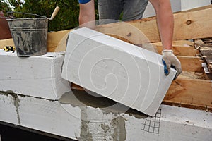 Bricklayer builder laying autoclaved aerated concrete blocks, aac for house wall