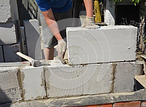 Bricklayer builder laying autoclaved aerated concrete blocks, aac for new house wall.  Autoclaved aerated concrete blocks walling photo