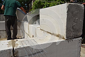 Bricklayer builder laying autoclaved aerated concrete blocks, aac for new house wall.  Autoclaved aerated concrete blocks walling