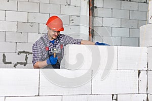 Bricklayer builder working with autoclaved aerated concrete blocks. Walling