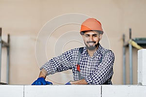 bricklayer builder working with autoclaved aerated concrete blocks. Walling, installing bricks on construction site