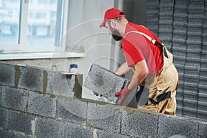 Bricklayer builder working with ceramsite concrete blocks. Walling