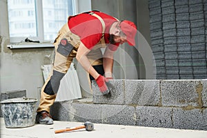 Bricklayer working with ceramsite concrete blocks. Walling