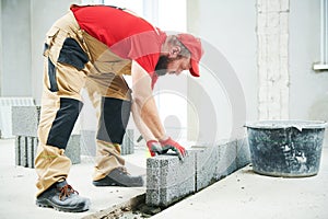 Bricklayer builder working with ceramsite concrete blocks. Walling