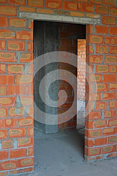 Bricklayer building new house with brick walls, interior rooms