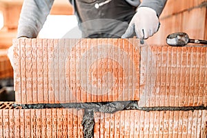 Bricklayer construction worker installing interior brick masonry