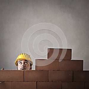 Bricklayer hiding behind a wall