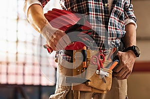 Bricklayer holding construction tools