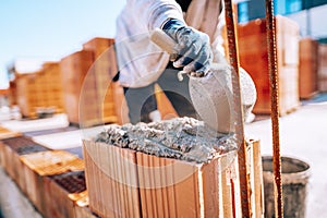 Bricklayer industrial worker installing brick masonry on exterior wall with trowel putty knife