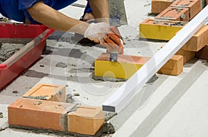 Bricklayer installing bricks, Bricklayer worker installing brick