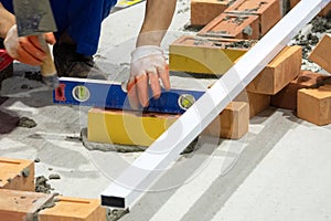 Bricklayer installing bricks, Bricklayer worker installing brick