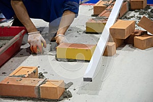 Bricklayer installing bricks, Bricklayer worker installing brick