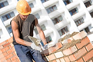 Bricklayer installing bricks with trowel tool