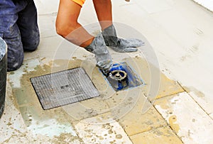 Bricklayer installing a drinking water stopcock on the sidewalk of a street.