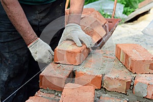 Bricklayer laying bricks. Bricklaying,  Masonry, Brickwork on new house wall construction site