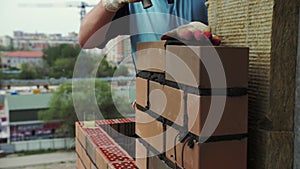 bricklayer lays bricks, exterior wall