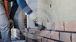 bricklayer lays bricks, exterior wall