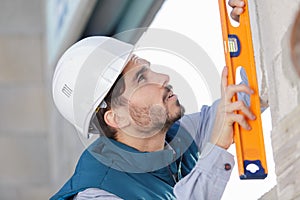 bricklayer measuring level wall