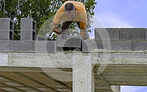Bricklayer putting down another row of bricks in site