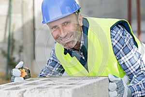 bricklayer putting down another row bricks in site