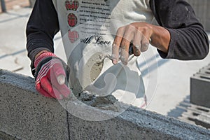 Bricklayer putting down another row of bricks in site
