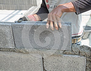 Bricklayer putting down another row of bricks in site
