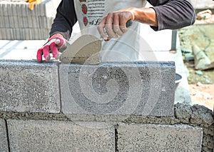 Bricklayer putting down another row of bricks in site