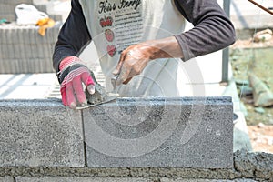Bricklayer putting down another row of bricks in site