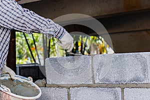 Bricklayer putting down another row of bricks in site.