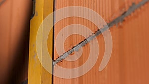 Bricklayer using a spirit level to check the wall and to draw a line with a pencil. Stock footage. Close up of man hands