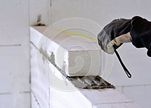 Bricklayer using a tape measure