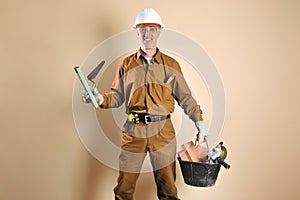 Bricklayer in work clothes holding tools and building materials