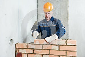 Bricklayer at work with red brick