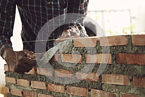 Bricklayer worker installing brick masonry