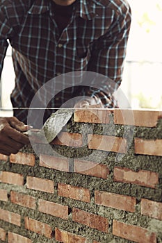 Bricklayer worker installing brick masonry