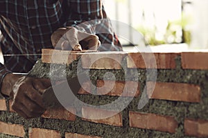 Bricklayer worker installing brick masonry