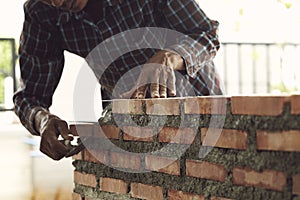 Bricklayer worker installing brick masonry