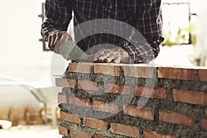 Bricklayer worker installing brick masonry