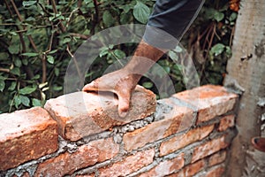 Bricklayer industrial worker installing old  bricks. masonry on exterior wall with old bricks and worker hands