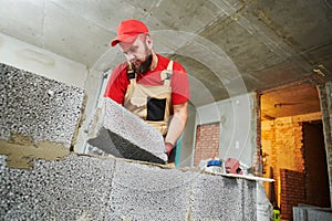 Bricklayer working with ceramsite concrete blocks. Walling