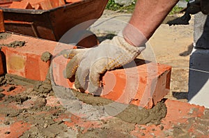 Bricklayers hands in masonry gloves bricklaying house wall. Bricklaying,  Masonry, Brickwork close up