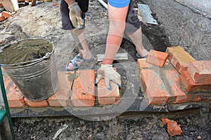 Bricklayers hands in masonry gloves bricklaying  new house wall on foundation