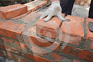 Bricklayers hands in masonry gloves bricklaying  new house wall photo