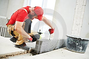 Bricklayer builder working with ceramsite concrete blocks. Walling photo