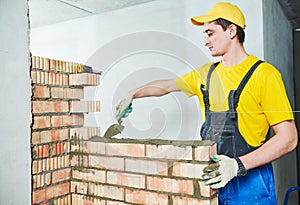 Bricklaying. Construction worker building a brick wall photo