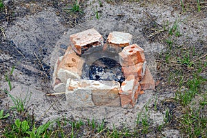 Bricks around the ash of an extinct fire on the ground