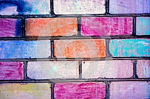 Bricks painted to rainbow color on brickwall. Brickwall as example of children art